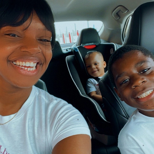 mother and sons in car smiling