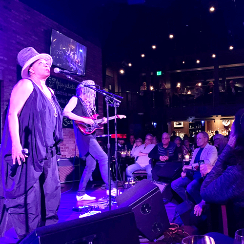 woman singing and man playing guitar on stage