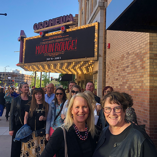 group of people in front of marquee sign for moulin rouge