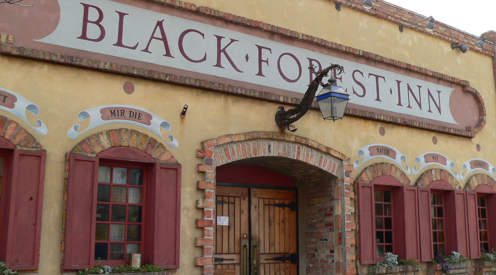 outside sign and front door of black forest inn