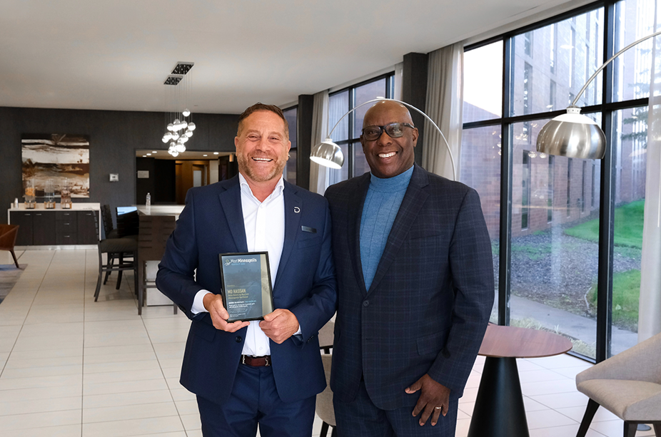 mo hassan accepting award from meet minneapolis ceo melvin tennant